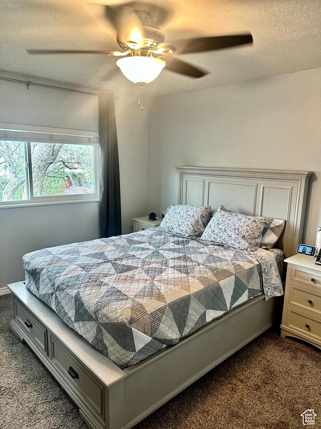bedroom with a ceiling fan, dark colored carpet, and a textured ceiling