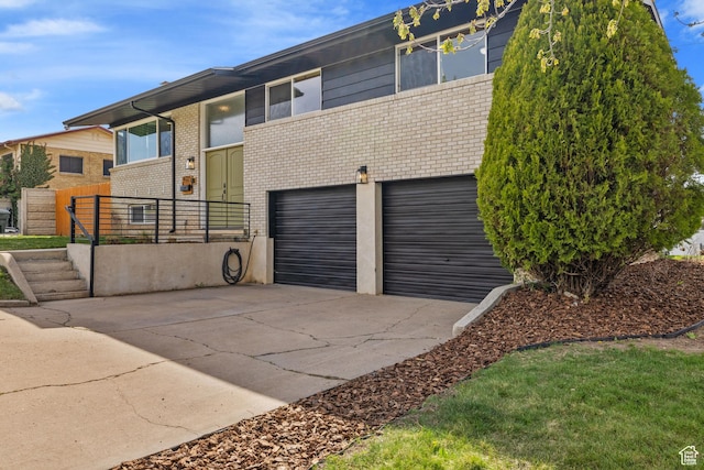 view of front of property with driveway, brick siding, and a garage