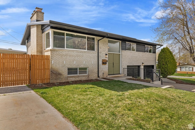 view of front facade with fence, a chimney, brick siding, and a front yard