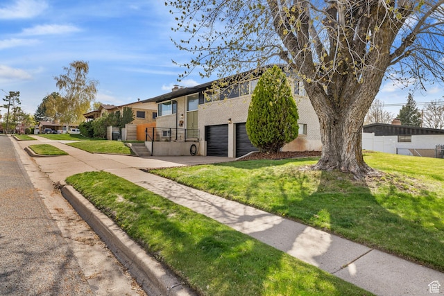 view of home's community featuring a lawn, an attached garage, and driveway