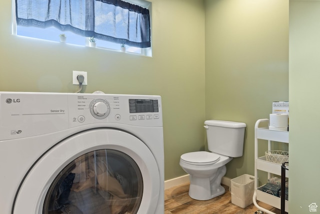 washroom with baseboards, wood finished floors, laundry area, and washer / clothes dryer