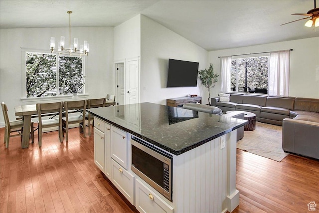 857 E Park School Rd, Draper, UT 84020 - kitchen featuring hardwood / wood-style flooring, stainless steel microwave, lofted ceiling, and open floor plan