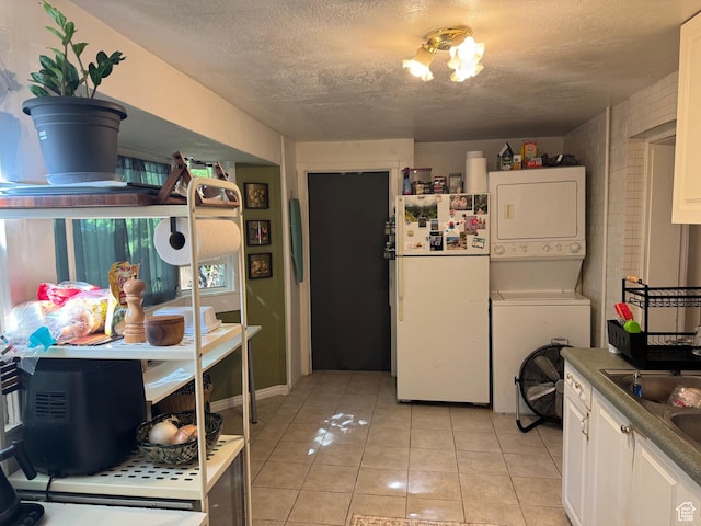 379 N 300 W, Logan, UT 84321 - kitchen featuring stacked washer and clothes dryer, freestanding refrigerator, a textured ceiling, and light tile patterned flooring