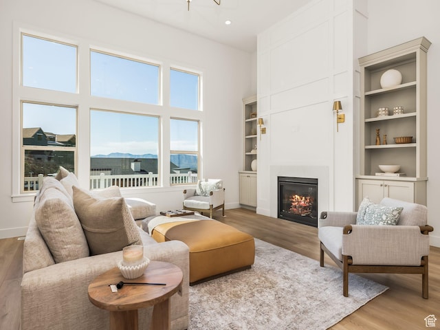 1554 S 920 E, Salem, UT 84653 - living room featuring a glass covered fireplace, light wood-type flooring, and baseboards
