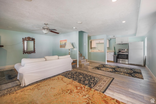 2201 S San Carlos Ct, Bloomington, UT 84790 - living room with a ceiling fan, baseboards, a textured ceiling, and light wood-style floors