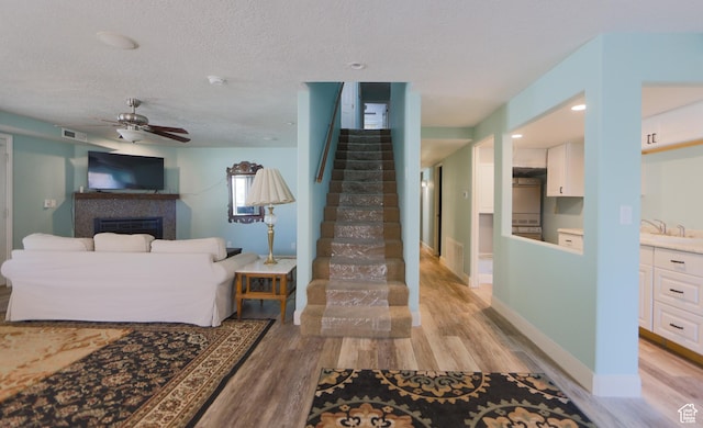 2201 S San Carlos Ct, Bloomington, UT 84790 - living room with light wood finished floors, a textured ceiling, and stairway