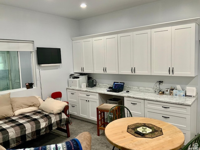 kitchen featuring dark carpet, white cabinets, light stone countertops, and recessed lighting