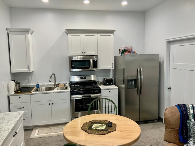 kitchen featuring appliances with stainless steel finishes, a sink, light countertops, and recessed lighting