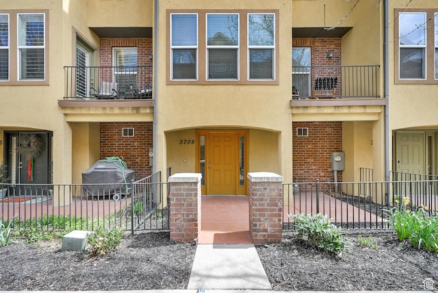3708 S Luchars Ln W, Salt Lake City, UT 84115 - view of front facade with stucco siding, brick siding, and fence