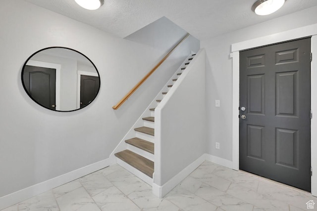 3708 S Luchars Ln W, Salt Lake City, UT 84115 - entrance foyer with baseboards, marble finish floor, a textured ceiling, and stairway