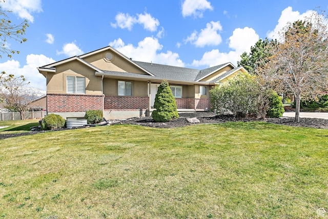 view of front of home with a front lawn, brick siding, and stucco siding