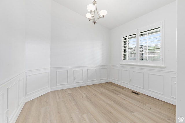 1354 S Star Cir W, Saratoga Springs, UT 84045 - empty room featuring vaulted ceiling, an inviting chandelier, a wainscoted wall, light wood finished floors, and visible vents