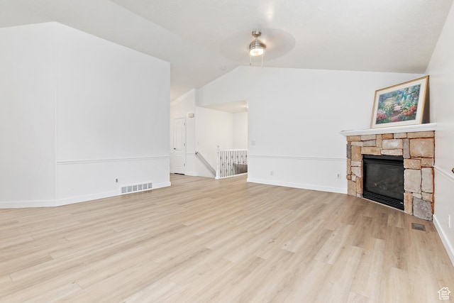 1354 S Star Cir W, Saratoga Springs, UT 84045 - unfurnished living room with baseboards, visible vents, light wood-style floors, lofted ceiling, and a stone fireplace