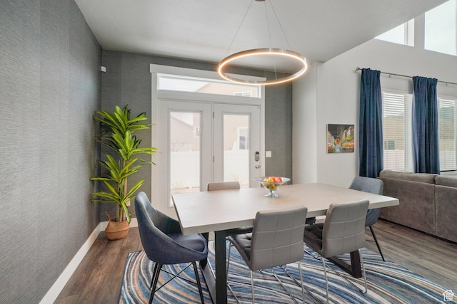 dining area with plenty of natural light, dark wood finished floors, and a notable chandelier