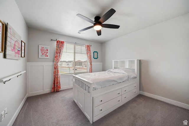 carpeted bedroom featuring wainscoting, a ceiling fan, and visible vents