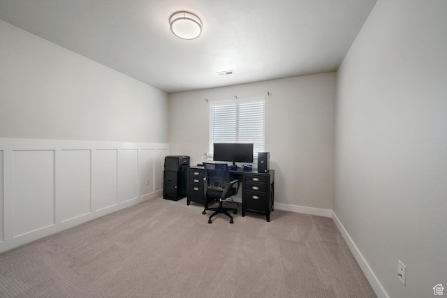 carpeted office with visible vents, wainscoting, and a decorative wall