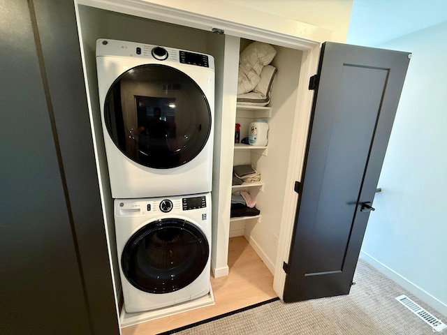 1739 S Main St E Unit 9, Salt Lake City, UT 84115 - washroom with stacked washer and dryer, baseboards, visible vents, carpet floors, and laundry area
