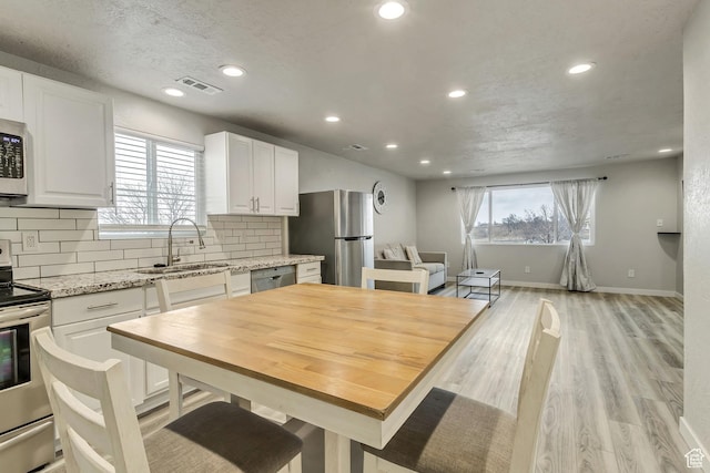3306 N Fairfield Rd, Layton, UT 84041 - kitchen featuring a sink, white cabinets, stainless steel appliances, and visible vents