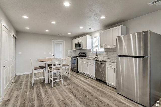 3306 N Fairfield Rd, Layton, UT 84041 - kitchen with visible vents, recessed lighting, white cabinets, and stainless steel appliances