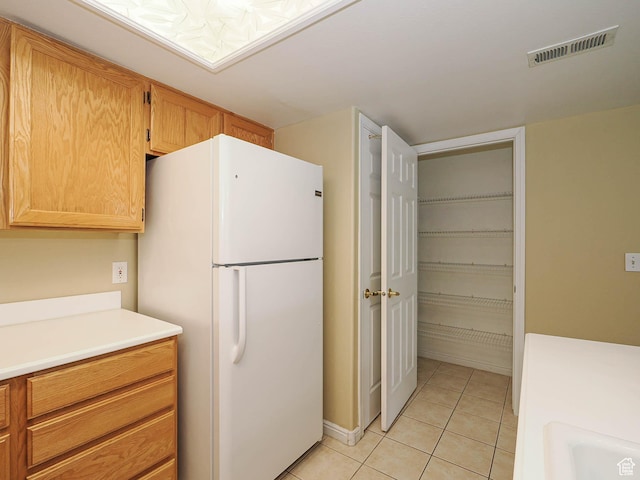 3832 S Big River Way W Unit 1, Salt Lake City, UT 84119 - kitchen featuring a sink, light tile patterned flooring, visible vents, freestanding refrigerator, and light countertops