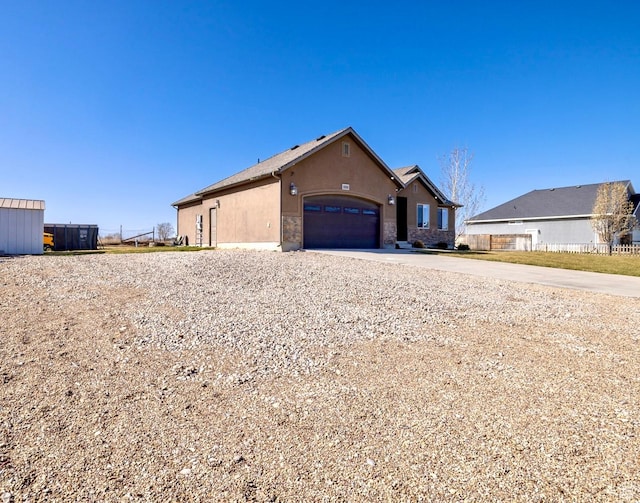 1808 E 2000 S, Naples, UT 84078 - view of front facade featuring stucco siding, stone siding, a garage, and concrete driveway