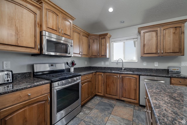 1808 E 2000 S, Naples, UT 84078 - kitchen featuring brown cabinets, appliances with stainless steel finishes, stone finish floor, and a sink