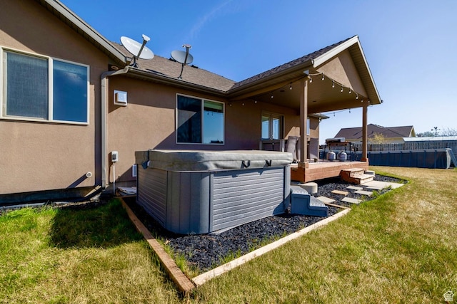 1808 E 2000 S, Naples, UT 84078 - rear view of property featuring stucco siding, fence, a hot tub, and a yard