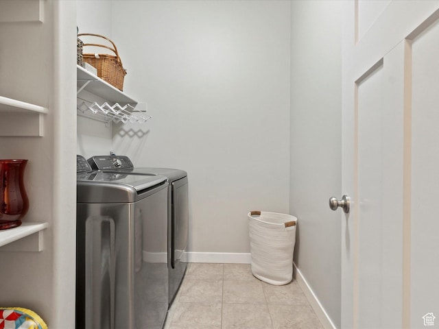 washroom with baseboards, independent washer and dryer, laundry area, and light tile patterned floors