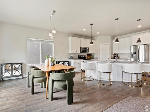dining room with wood finished floors and recessed lighting