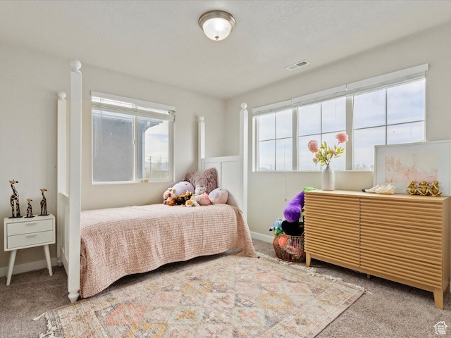 carpeted bedroom featuring visible vents