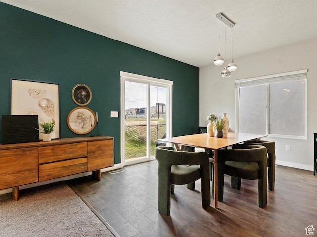 dining space with baseboards and dark wood-style flooring