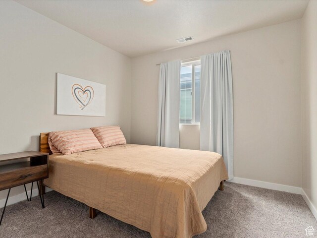 carpeted bedroom with visible vents and baseboards