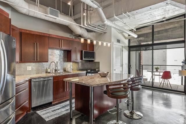 328 W 200 S Unit 505, Salt Lake City, UT 84101 - kitchen featuring stainless steel appliances, a sink, a center island, finished concrete floors, and tasteful backsplash