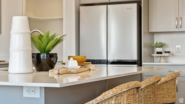 details featuring gray cabinetry, light countertops, and freestanding refrigerator