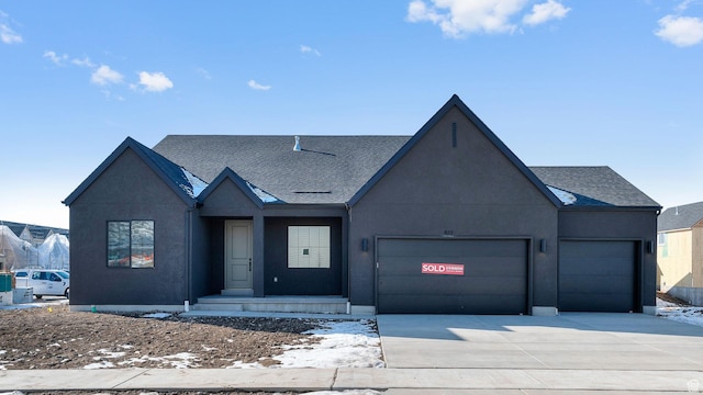 view of front of property with stucco siding, a shingled roof, concrete driveway, and a garage