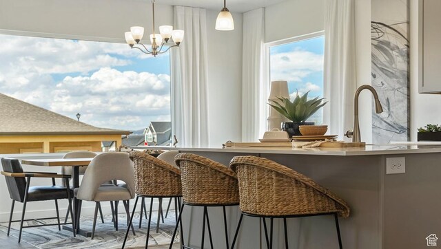 dining space with wood finished floors and an inviting chandelier