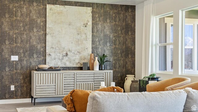 living area with baseboards and wood finished floors