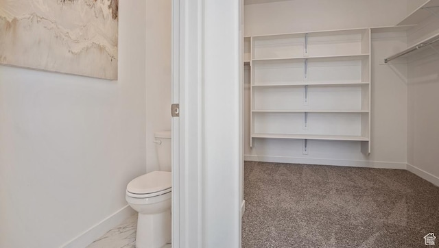 bathroom featuring marble finish floor, baseboards, and toilet