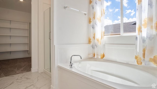 full bath with a shower stall, marble finish floor, a garden tub, and a wealth of natural light