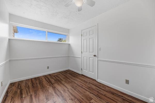empty room with baseboards, wood finished floors, a textured ceiling, and ceiling fan