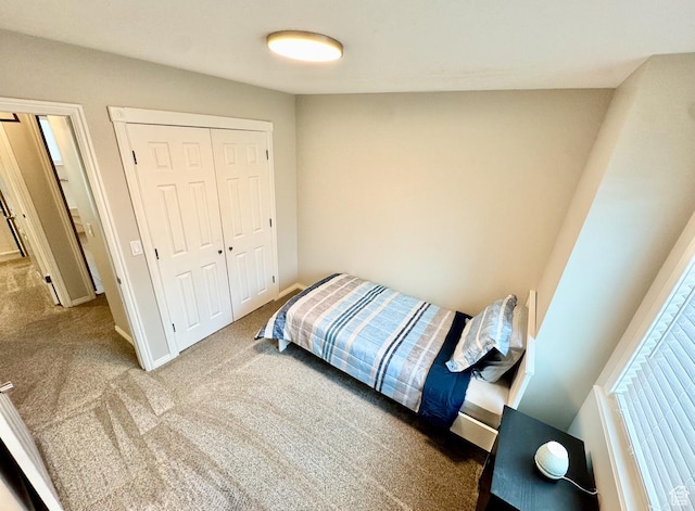 bedroom with carpet, a closet, and baseboards