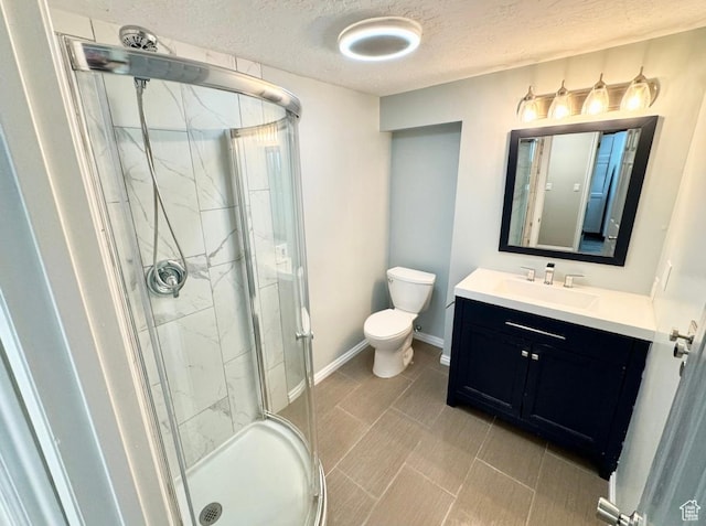 full bath with toilet, a textured ceiling, a stall shower, vanity, and baseboards