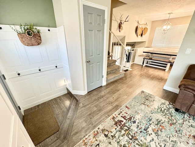 interior space featuring wood finished floors, baseboards, and stairway