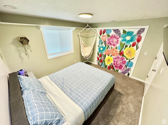 bedroom featuring a textured ceiling, carpet flooring, and baseboards