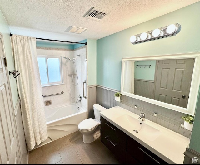 bathroom with shower / bath combo, toilet, wainscoting, visible vents, and vanity