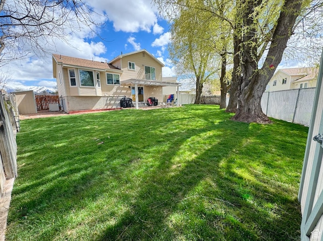 back of property with a fenced backyard and a yard