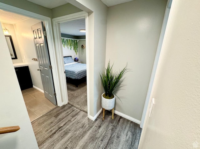 corridor featuring wood finished floors and baseboards