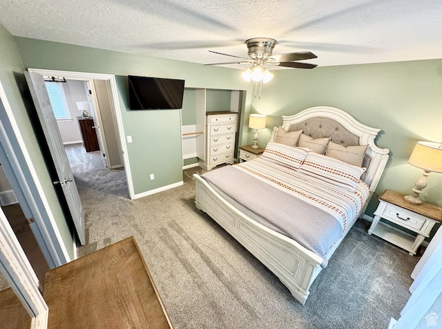 bedroom with ceiling fan, baseboards, carpet flooring, and a textured ceiling