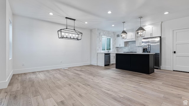 kitchen with light countertops, baseboards, stainless steel refrigerator with ice dispenser, dishwasher, and a kitchen island