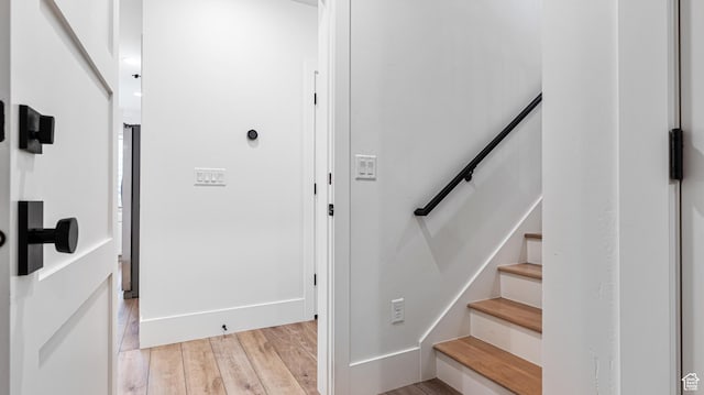 stairs with wood finished floors and baseboards